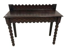 Late 19th century gothic revival oak side table the raised back carved with repeating rosette and fl