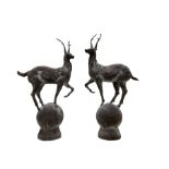 Pair of cast iron garden stag finials atop a sphere base