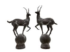 Pair of cast iron garden stag finials atop a sphere base