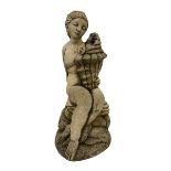 Composite stone garden ornament or water feature in the form of a nude maiden seated on rocks