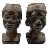 Pair of African carved iron wood male heads each wearing a Kofia cap H18cm