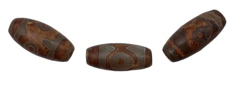 Three Tibetan Dzi stone beads each with decorative symbols approx 3cm long