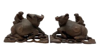 Pair of late 19th century Chinese carved recumbent water buffalo each with a boy on its back and on