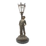 French patinated spelter table lamp modelled as a boy leaning against a street lamp