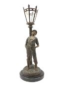 French patinated spelter table lamp modelled as a boy leaning against a street lamp