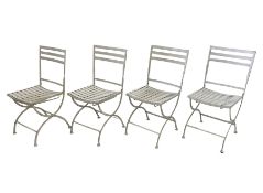 Set of four white finish wrought metal strapwork folding garden chairs