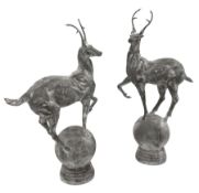 Pair of cast metal garden figures or gate post finials in the form of stags on spherical mounts
