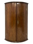 Early 19th century oak bow fronted corner wall cupboard