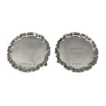 Pair of modern silver circular card trays with pie crust borders and scroll feet