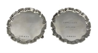 Pair of modern silver circular card trays with pie crust borders and scroll feet