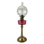 19th/ early 20th century brass oil lamp with cranberry glass reservoir