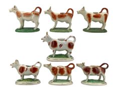 Seven Victorian Staffordshire cow creamers with brown markings
