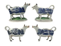 Two Victorian Staffordshire cow creamers with blue and white printed Willow pattern bodies on green