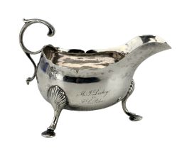 18th century Irish silver cream jug with crimped rim and C scroll leaf capped handle and hoof feet w