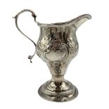 George III silver baluster cream jug with scroll handle and later embossed decoration