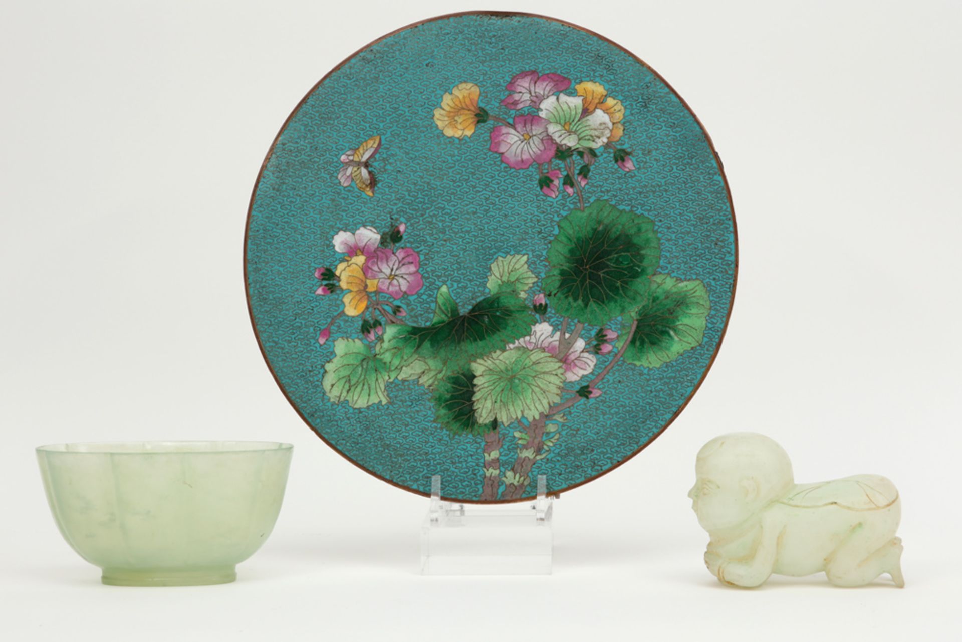 two Chinese jade pieces (bowl and baby figure) and a round cloisonné plate || Lot (3) met een kom en