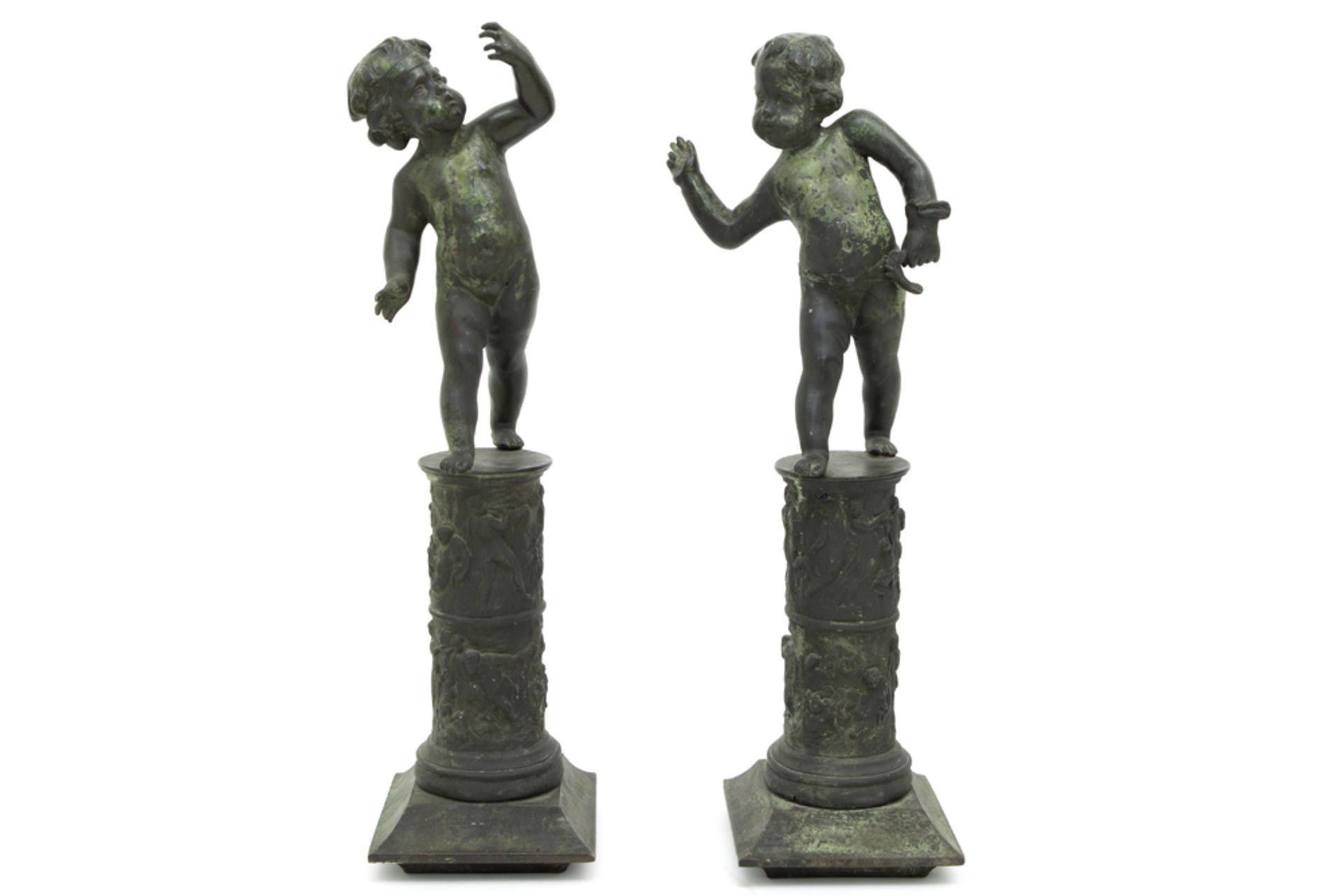 pair of antique garden sculptures in bronze with green patina each with a child, standing on a