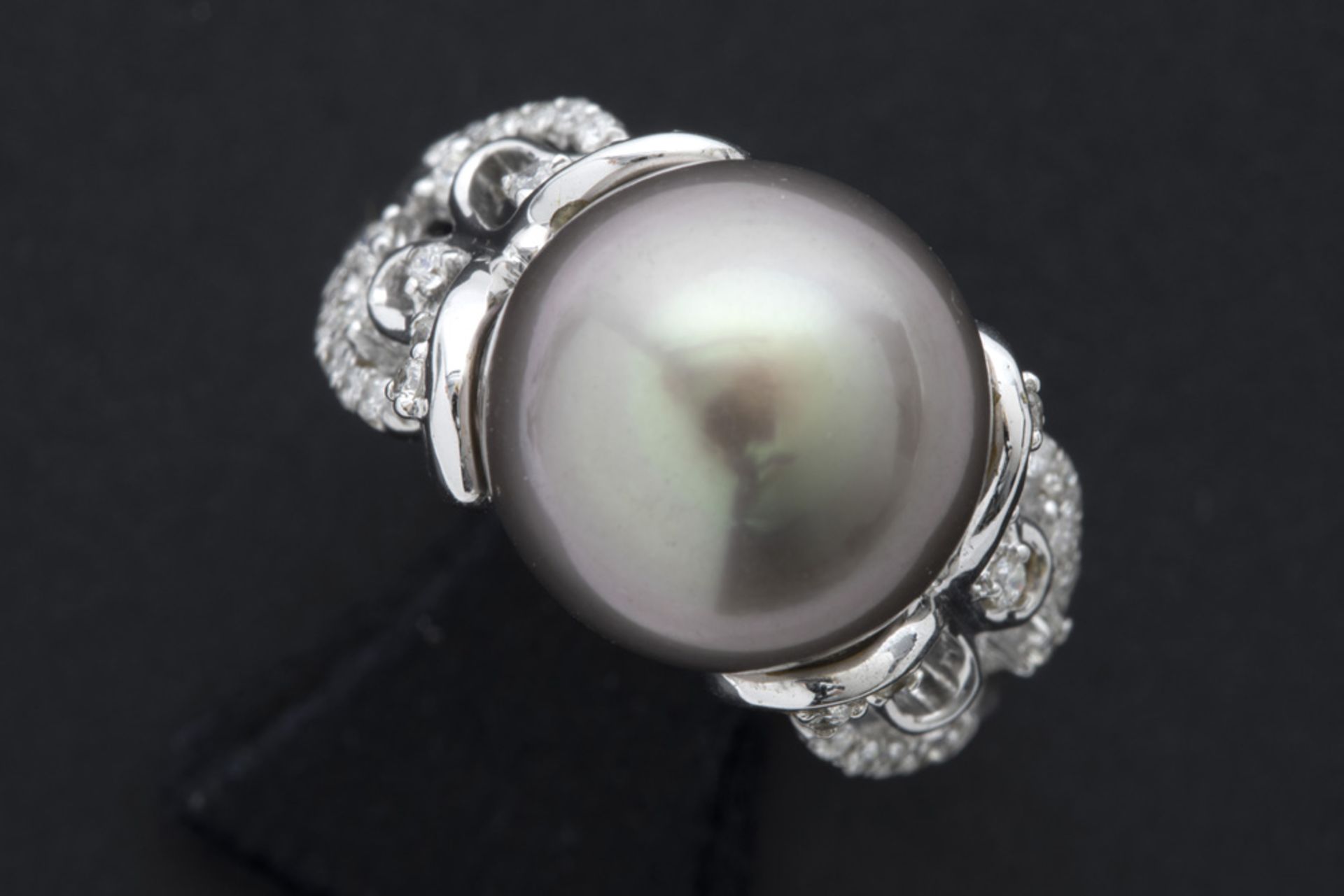 nicely made ring in white gold (18 carat) with a grey pearl and ca 0,40 carat of high quality
