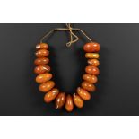 old ethnic necklace wit seventeen quite large amber beads, of which some are repaired with metal||