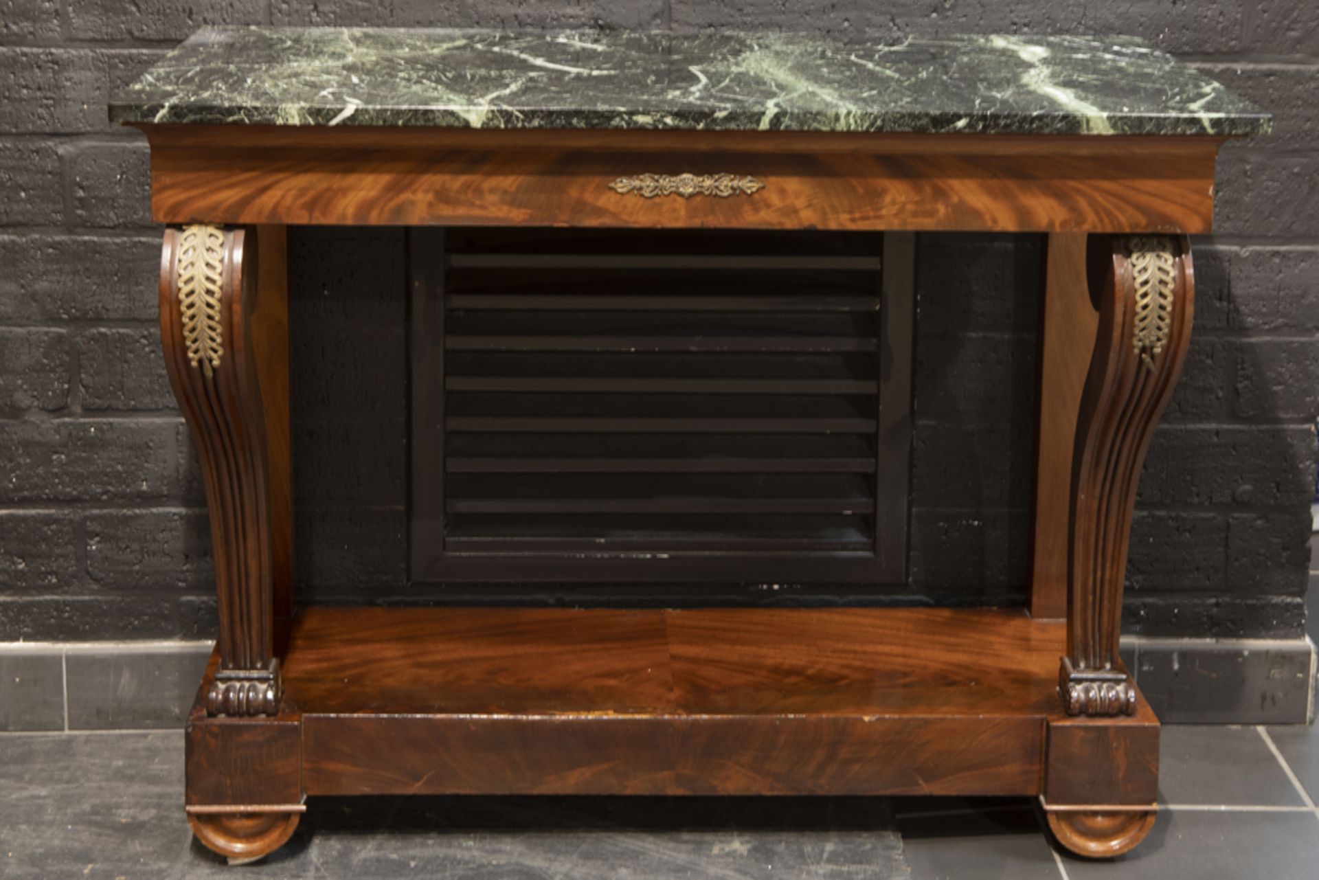 19th Cent. console in mahogany with a black marble top||Negentiende eeuwse console met voluutvormige