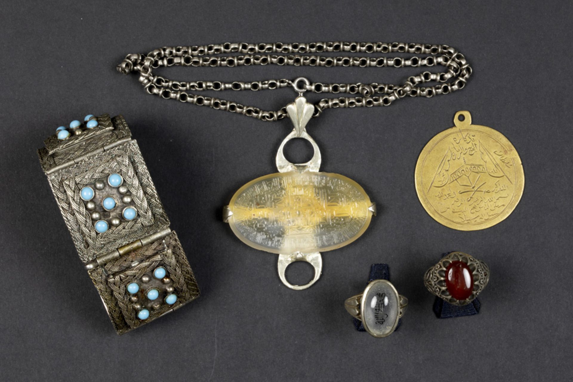 lot (5) oriental jewelry with a silver bracelet, two rings, a pendant with chain and a commemorative