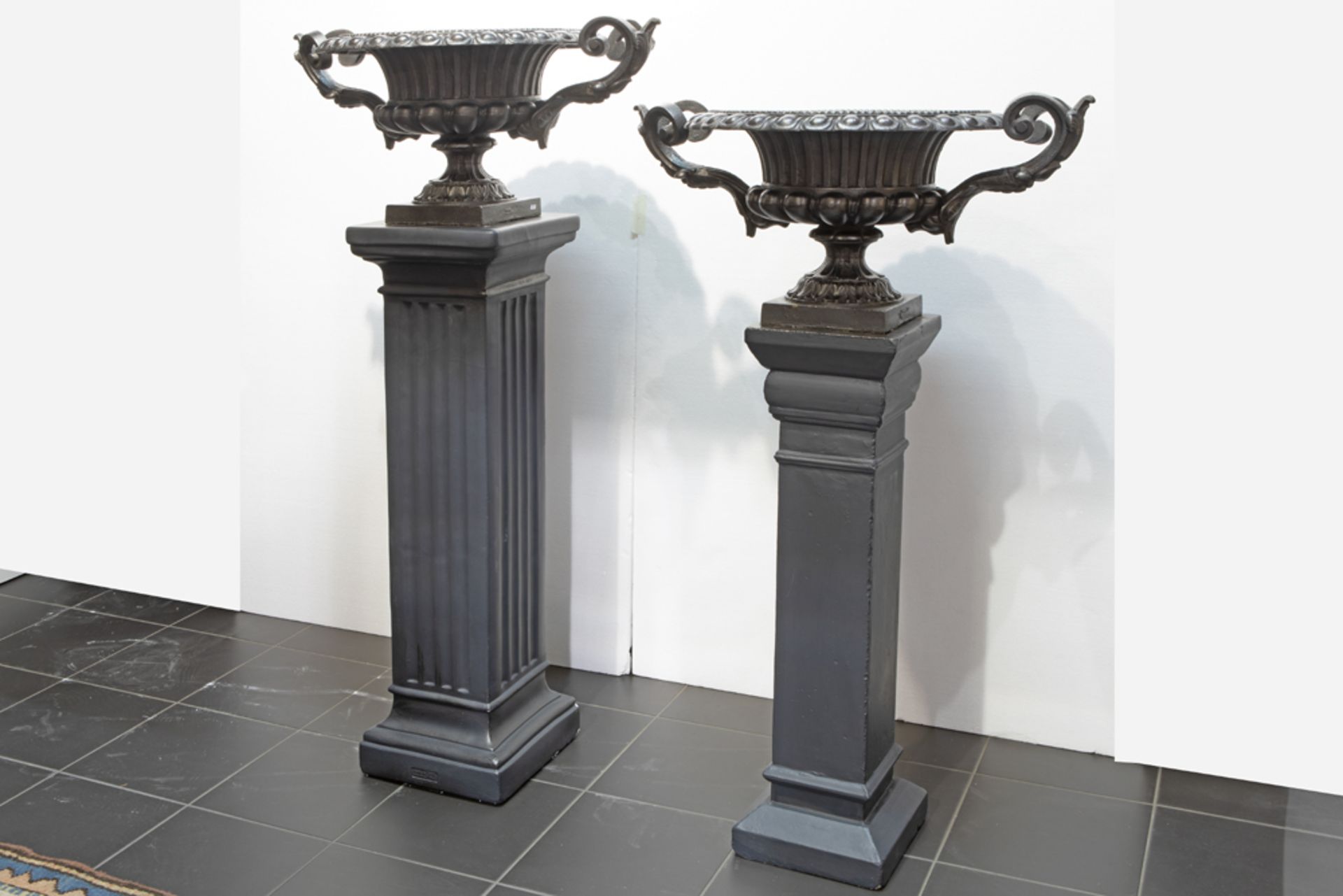 pair of garden urns in cast iron - each on a pedestal||Paar tuinurnes met grepen in gietijzer -