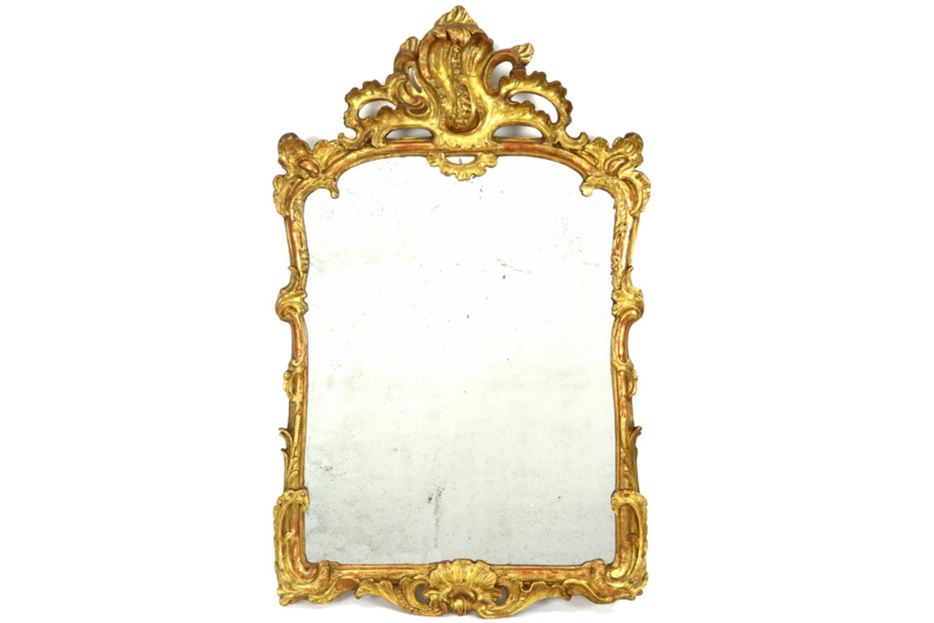 mirror with an 18th Cent. French Louis XV style frame in gilded and sculpted wood with on the back a