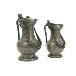 two antique Swiss' lidded chain pitchers in pewter - the largest of which is marked "Wallis/ Schweit