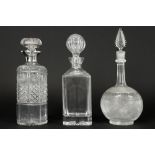 three decanters in clear crystal, one with a collar in English marked silver||Lot van drie 'antieke'