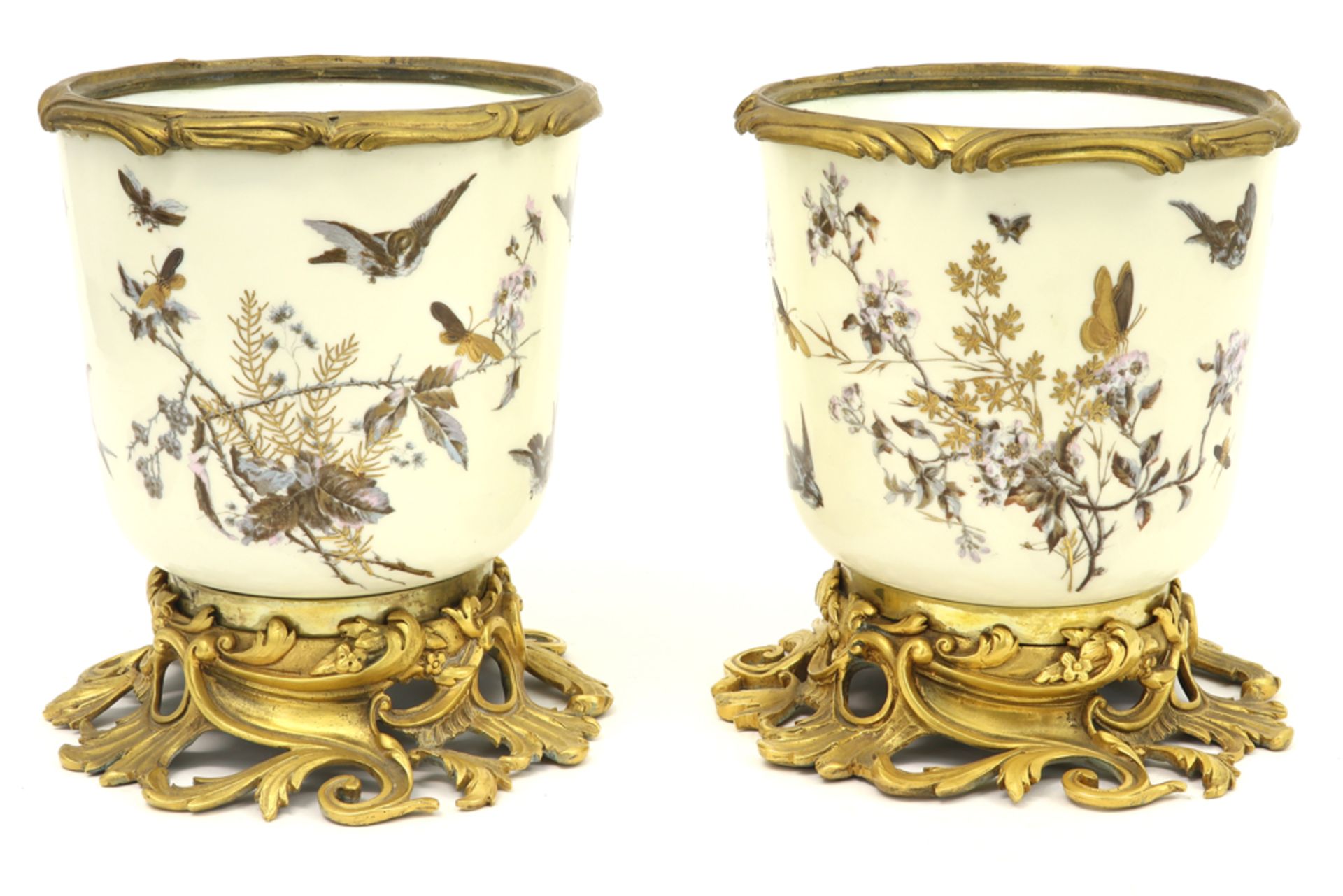 pair of 19th Cent. jardiniers in porcelain from Paris with a gilded bronze mounting||Paar
