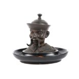 antique inkwell in patinated metal depicting the head of a Chinese Mandarin - on an oval wooden base