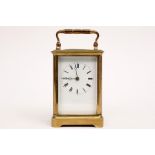 small antique travel clock in brass with a French work and with a signed plate