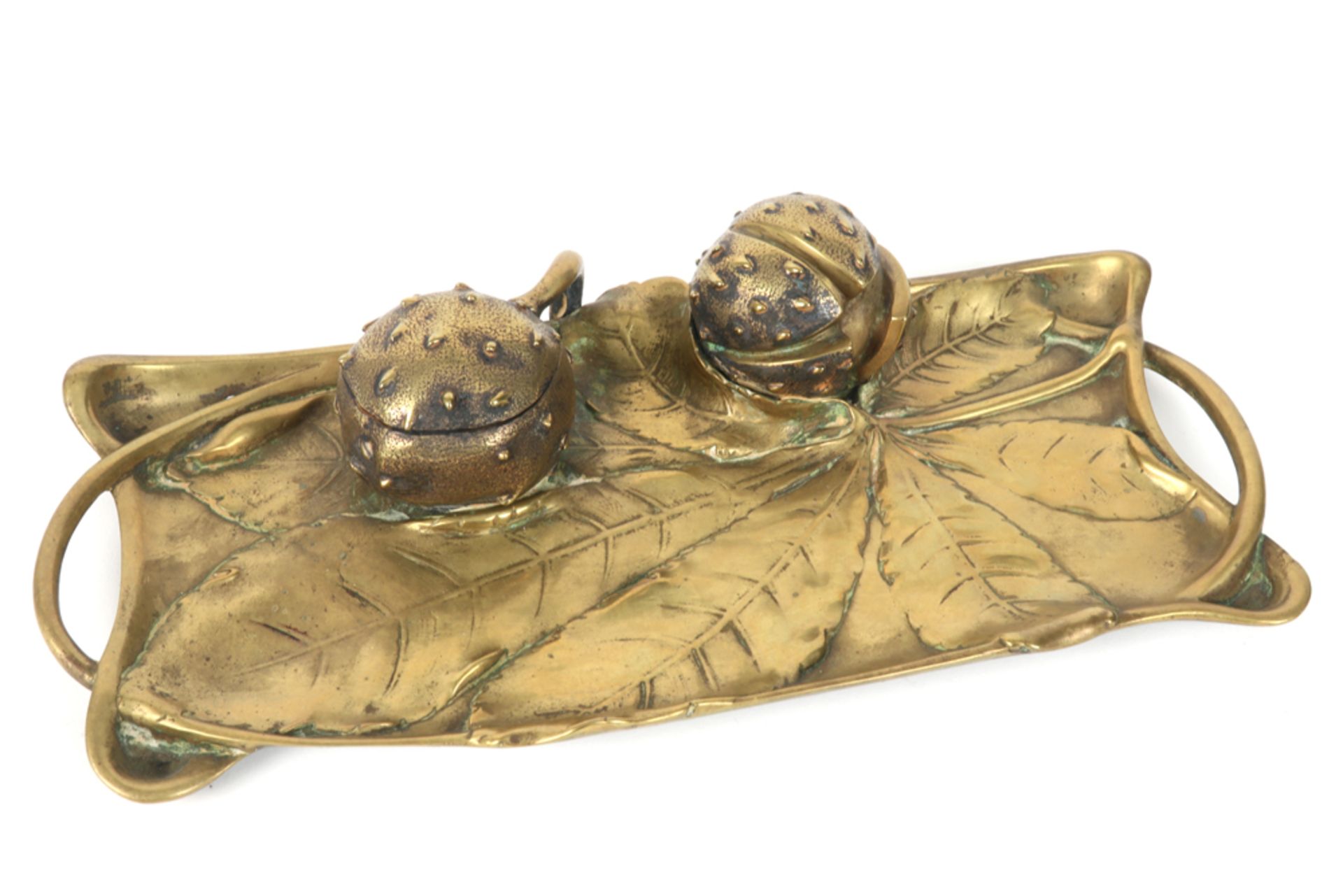 Art Nouveau inkstand in brass with vegetal ornamentation with two chestnuts
