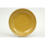 Chinese plate in marked porcelain with a mustard yellow glaze