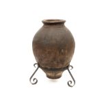 antique earthenware wine jug (seabed find) with a stand in wrought iron