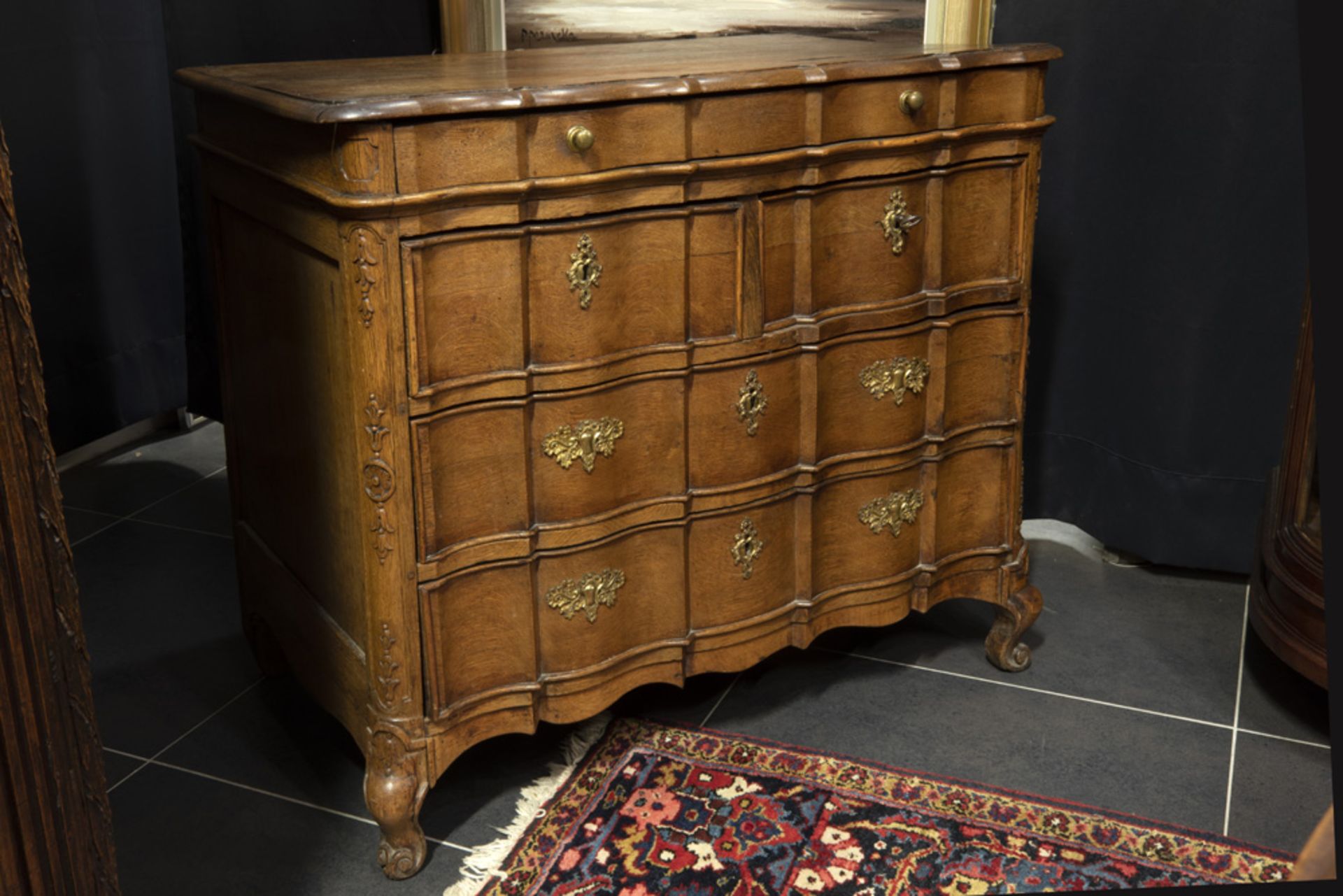 antique oak chest of drawers with a serpentine curved front and with sculpted Louis XV ornaments