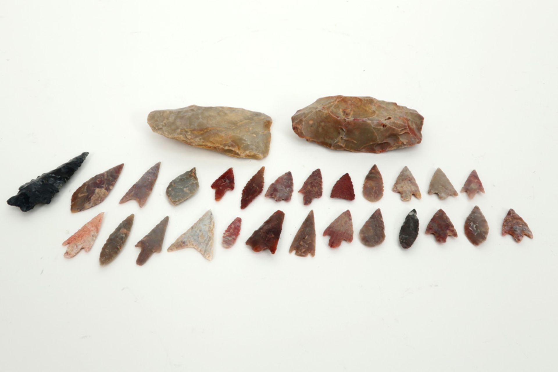 28 Prehistorical stone implements : 2 axes, 25 arrows and a spear point