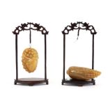 two Chinese pendatives in the shape of a fruit in a yellow type of stone - each with standard ||Twee