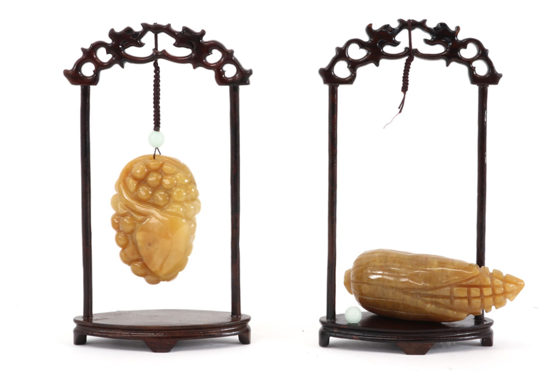 two Chinese pendatives in the shape of a fruit in a yellow type of stone - each with standard ||Twee