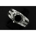 a 2,70 carat black diamond set in a ring in white gold (18 carat) with ca 0,80 carat of white