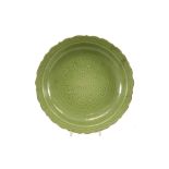 Chinese dish in earthenware with green celadon glaze and underlying vegetal decor ||Chinese schaal