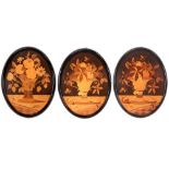 three oval marquetry panels, each with a flower still life ||Lot van drie antieke ovale paneeltjes
