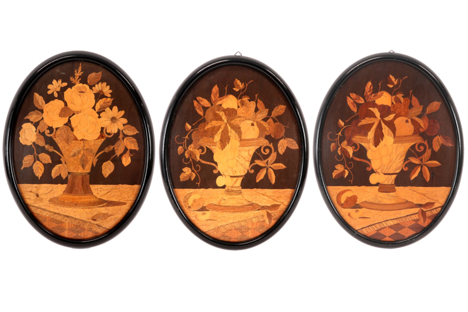 three oval marquetry panels, each with a flower still life ||Lot van drie antieke ovale paneeltjes
