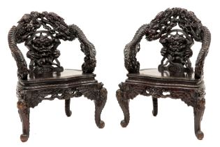 pair of antique Chinese armchairs in richly sculpted wood with a decor of dragons || Paar antieke