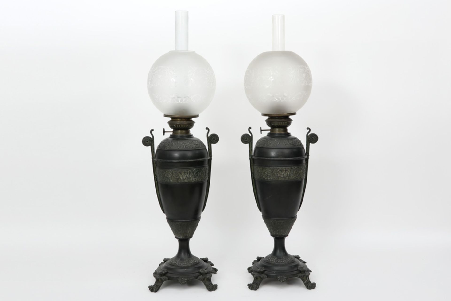 pair of antique paraffin lamps in patinated metal with neoclassical ornamentation || Paar antieke