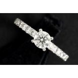 a 0,60 carat quality brilliant cut diamond set in a ring in white gold (18 carat) with ca 1 carat of