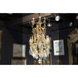 chandelier in bronze and crystal || Luster met bronzen montuur versierd met plaketten en bellen in