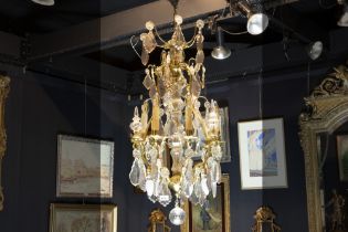 chandelier in bronze and crystal || Luster met bronzen montuur versierd met plaketten en bellen in