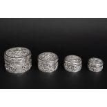four small round lidded Chinese boxes in marked silver || Reeks van vier ronde in elkaar passende