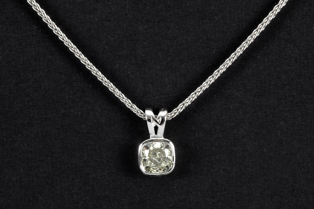 a 0,64 carat fancy light yellow high quality cushion cut diamond set in a pendant in white gold (